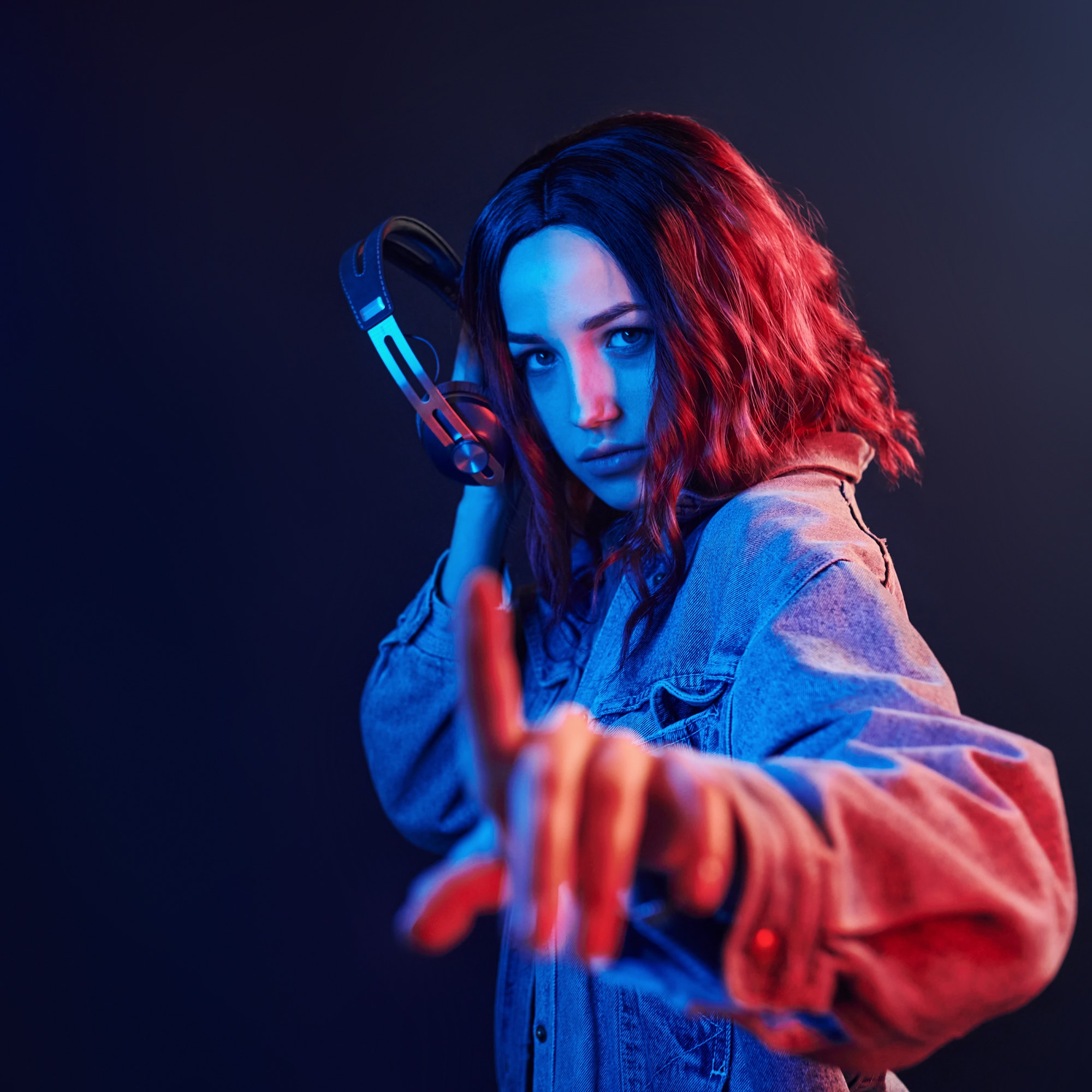 portrait-of-young-girl-that-listening-to-music-in-headphones-in-red-and-blue-neon-in-studio.jpg